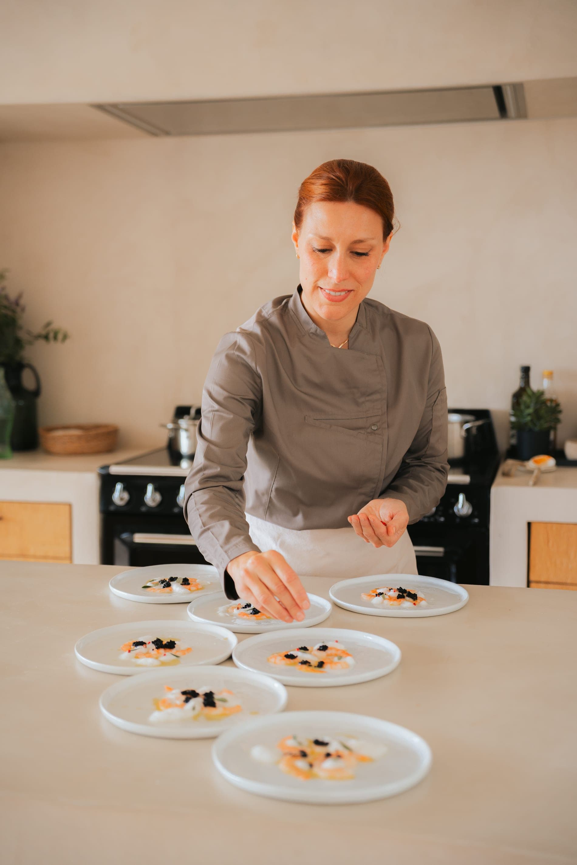 Chef Lara Petrella serving in a bright Costa Brava villa, garden in view