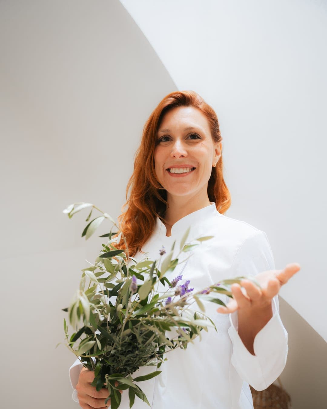 Chef Lara Petrella holding a bouquet of fresh olive branches and lavender