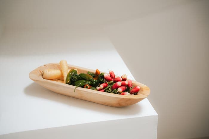 Fresh market vegetables in a wooden bowl — parsnip, chillies and radishes