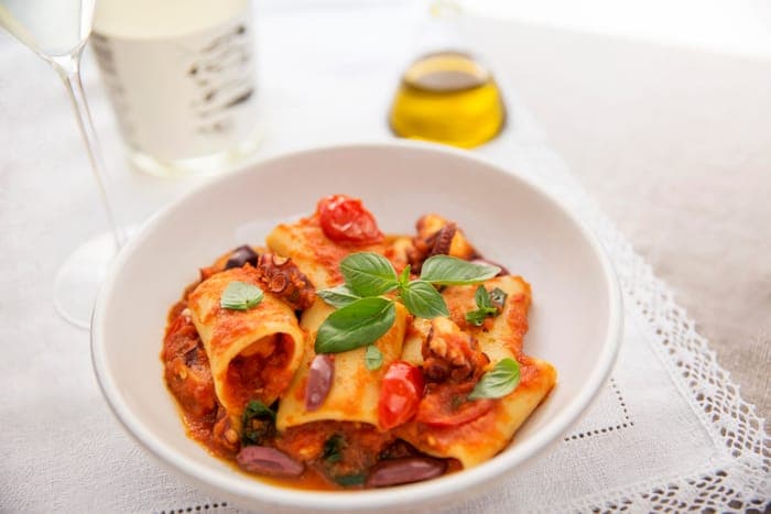 Paccheri pasta in tomato sauce with olives and basil