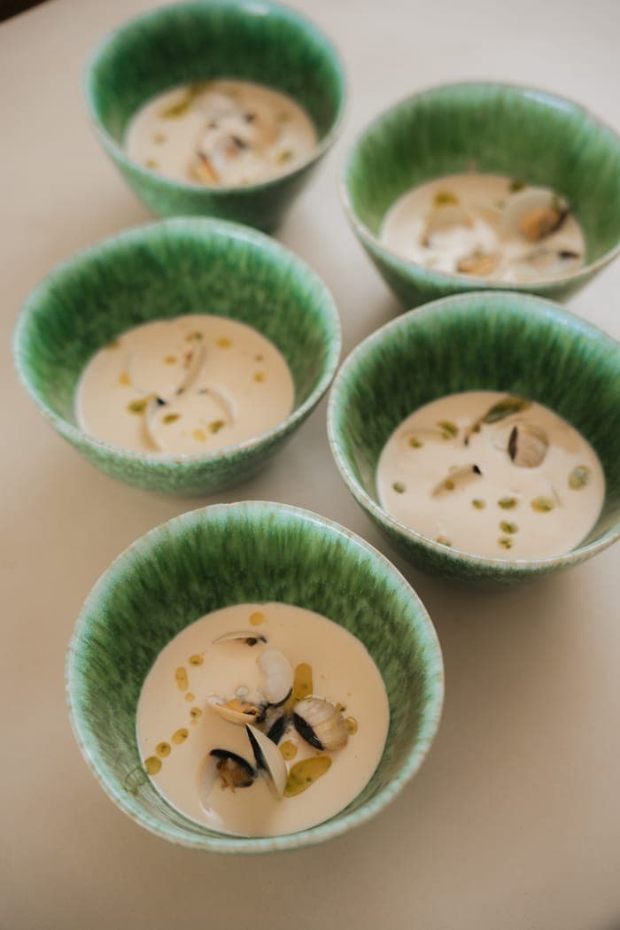 Chilled shellfish soup served in green ceramic bowls