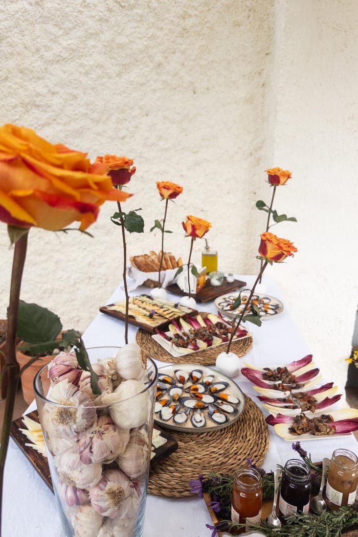 A canapé table set with roses, garlic and mussel appetizers