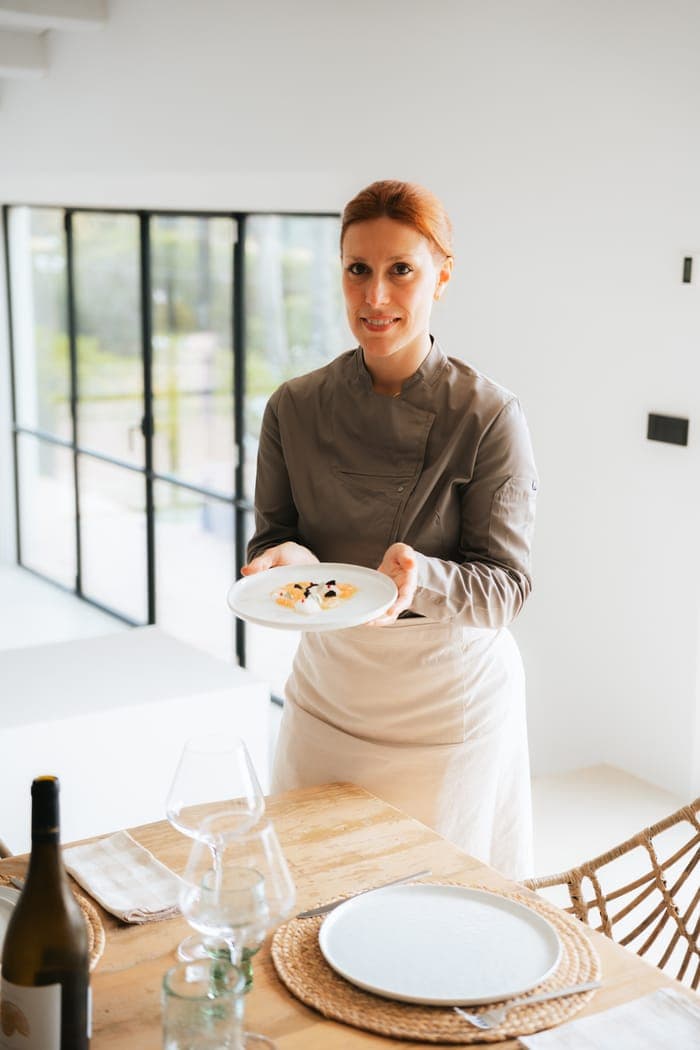 Chef Lara Petrella presenting a finished plate at a villa dinner